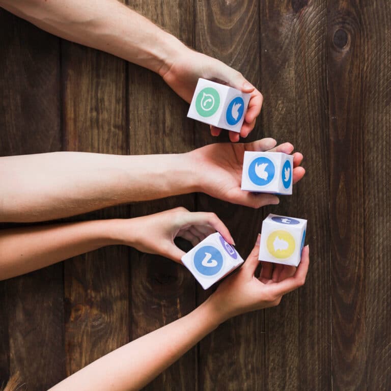 4 hands holding cubes with social media logos
